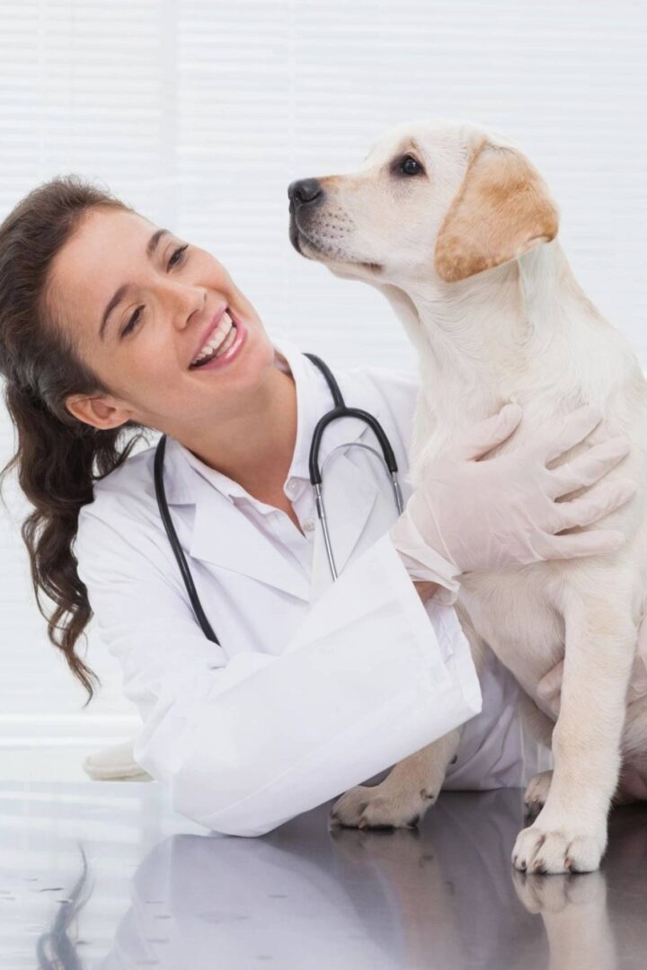 A woman in white coat holding a dog.