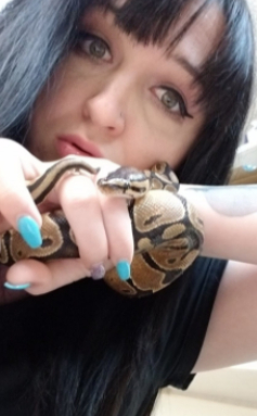 A woman holding a snake in her hand.